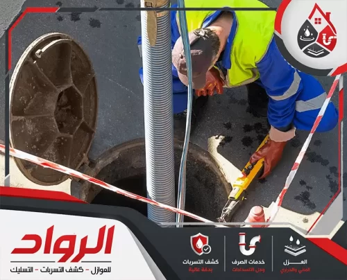 فنيًا يعمل بجانب فتحة صرف أرضية مفتوحة، مع وجود خرطوم شفط ومعدات ميدانية للتعامل مع الانسدادات وتجمعات الصرف داخل غرف التفتيش وخطوط المجاري.