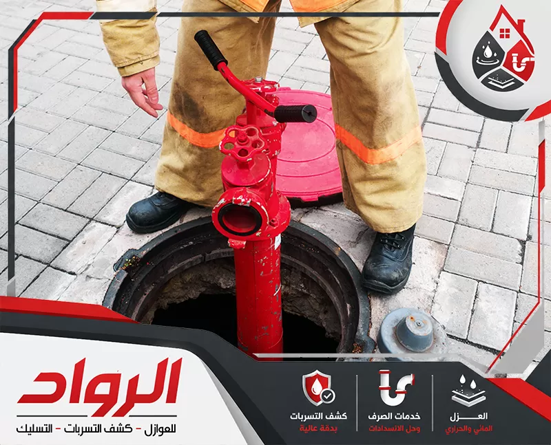 أتصل الأن بأفضل شركة تسليك مجاري بالقطيف 0562647138 شركة الرواد عاملًا يتعامل مع فتحة صرف أو غرفة تفتيش أرضية باستخدام معدة حمراء مخصصة، ما يعبر عن أعمال فحص شبكات الصرف، فتح المجاري، والتعامل مع الانسدادات داخل الخطوط الأرضية.
