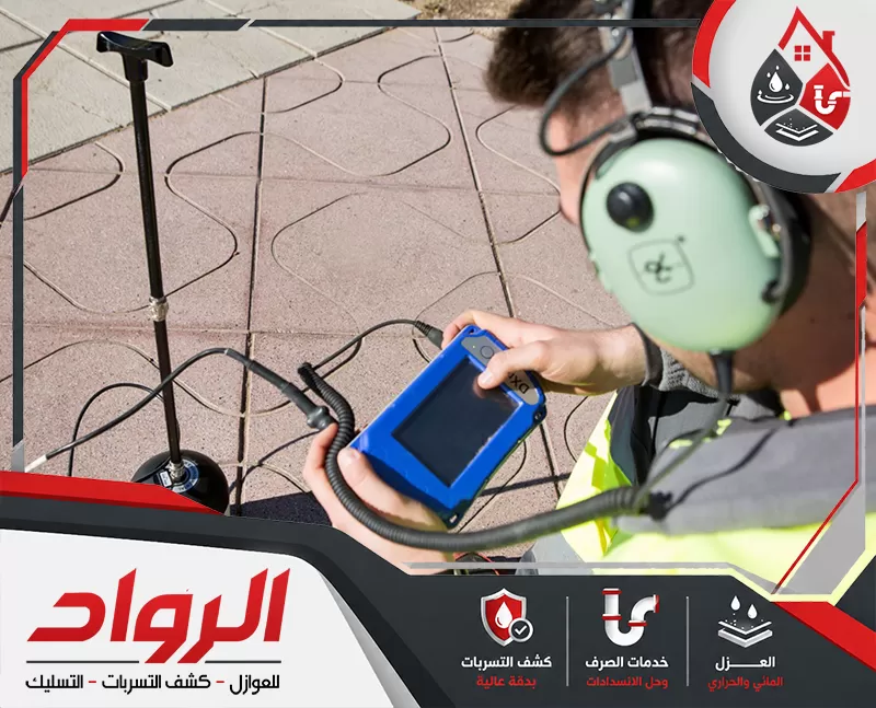 أتصل الأن بأفضل شركة كشف تسربات المياه بالدمام 0562647138 شركة الرواد فنيًا يستخدم جهاز فحص ميداني وسماعات مخصصة لتتبع مصدر التسرب أسفل البلاط، مع ظهور معدات كشف متصلة بالأرض لتحديد موضع المشكلة بدقة.