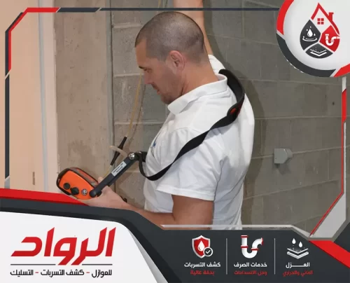 فني يستخدم جهاز كشف تسربات المياه بجازان لفحص الجدران والمواسير.